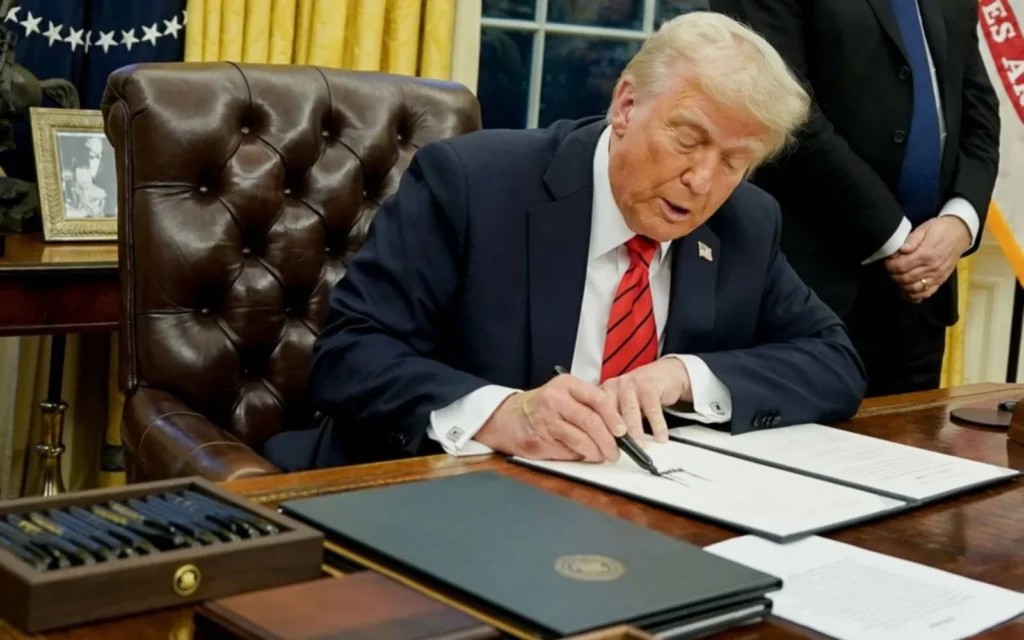Donald Trump duduk di meja kerjanya di Gedung Putih saat mengumumkan tarif impor trump 32% untuk produk Indonesia.
